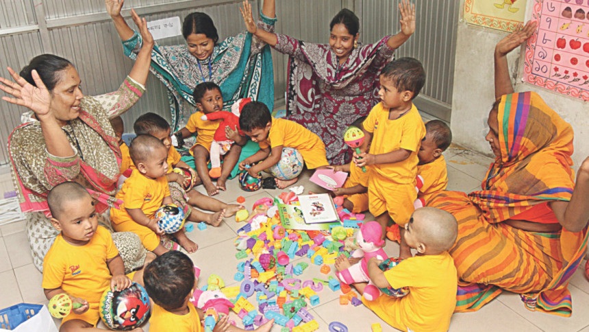 Who is holding the baby while she works?