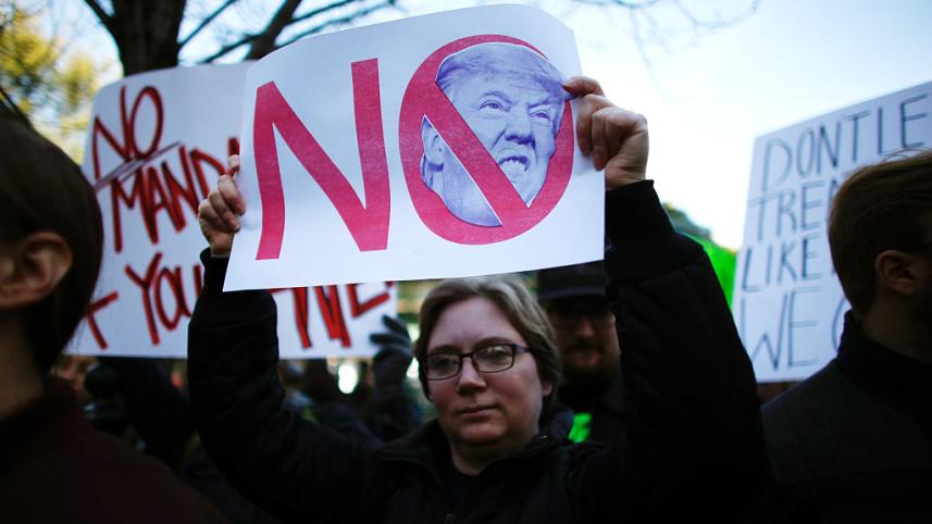 A woman holds a poster