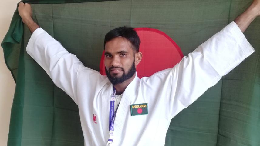 Al Amin poses with the national flag of Bangladesh 