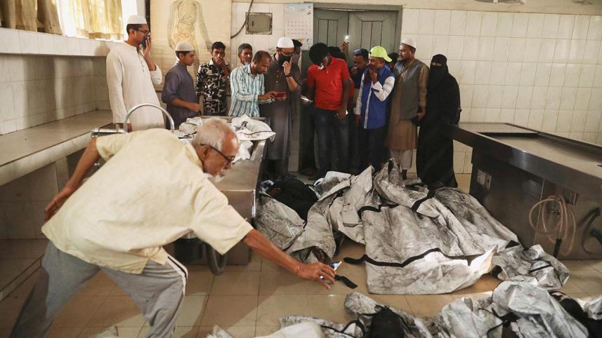 Relatives of victims of a fire incident attempt to identify the bodies at Dhaka Medical College Hospital
