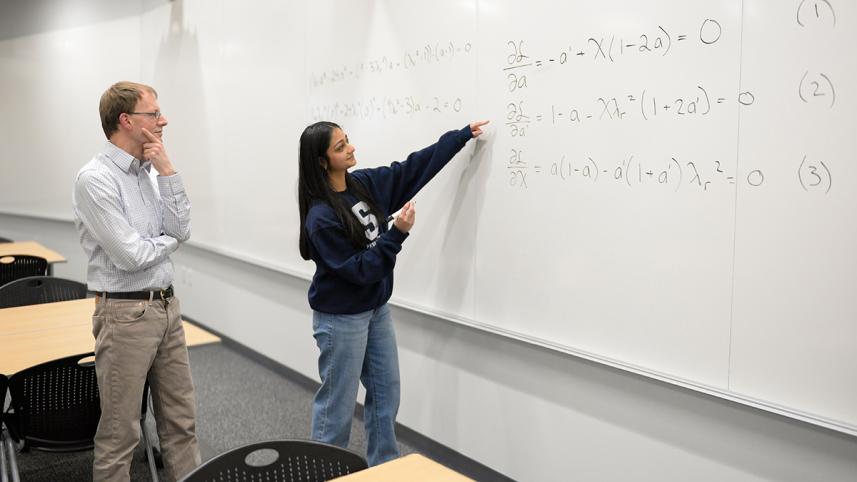 divya_tyagi_right_a_penn_state_engineering_graduate_student_shows_her_work_on_a_century-old_math_problem_to_sven_schmitz_a_college_of_engineering_faculty_member_and_tyagis_adviser._credit_-_kevin_sliman.jpg