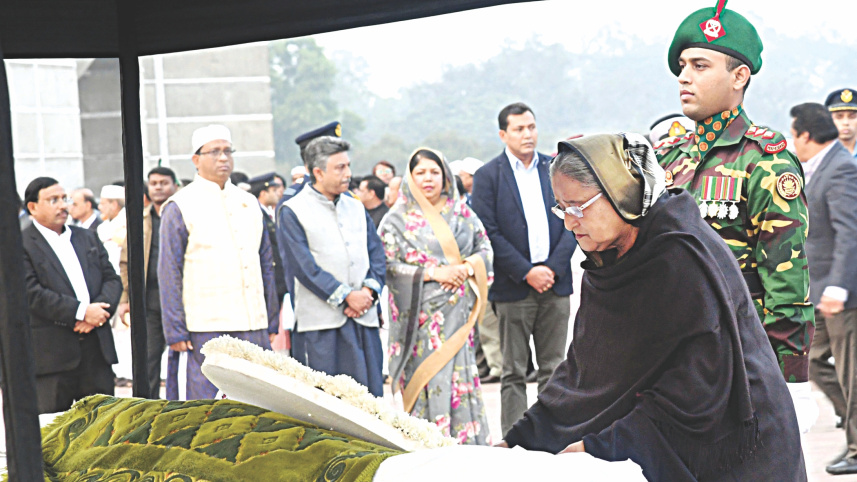 hasina_places_wreath_at_coffin.jpg
