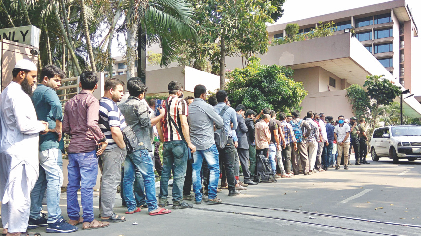 Migrant workers waiting in a long queue on the Sonargaon hotel 