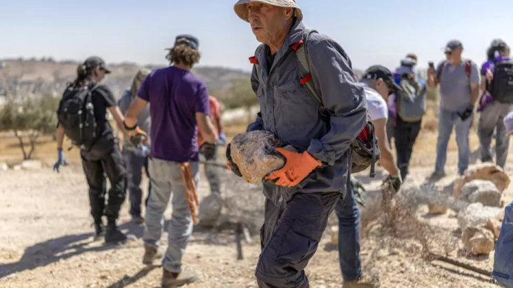 Israeli left-wing activists remove obstacles as they attempt to reopen a road that was blocked by Israeli settlers in the occupied West Bank Palestinian village of Jannatahon the outskirts of Bethlehem on August 25, 2026. Photo: AFP