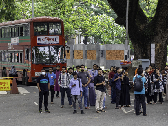 Group of students waiting at the bus stop in the Dhaka University campus.