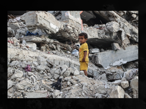 A Palestinian child stands on the rubble of a destroyed building near the Shati refugee camp in western Gaza City AFP (2).png