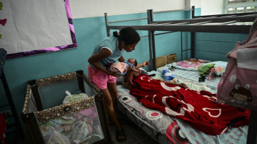 Scarlett Goitia carries the baby of her sister Eliana Garcia, who gave birth to a boy in a baseball field hours after the twin earthquakes that rocked Venezuela. Photo: AFP