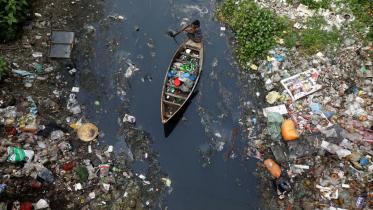 Collecting plastic material from dirty water in Dhaka