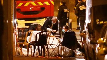 Rescuers cover a victim's body