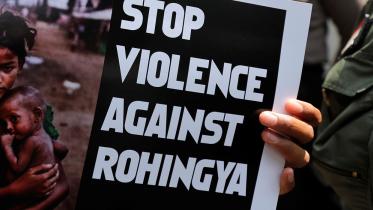 A protester holds a placard during protest against Myanmar's treatment