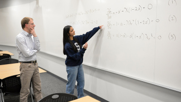 divya_tyagi_right_a_penn_state_engineering_graduate_student_shows_her_work_on_a_century-old_math_problem_to_sven_schmitz_a_college_of_engineering_faculty_member_and_tyagis_adviser._credit_-_kevin_sliman.jpg