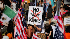 A protester holds a sign reading "NO KINGS" with a crown illustration crossed out during a "No Kings" protest against U.S. President Donald Trump's policies, outside City Hall in Los Angeles, California, U.S., October 18, 2025. Photo: Reuters