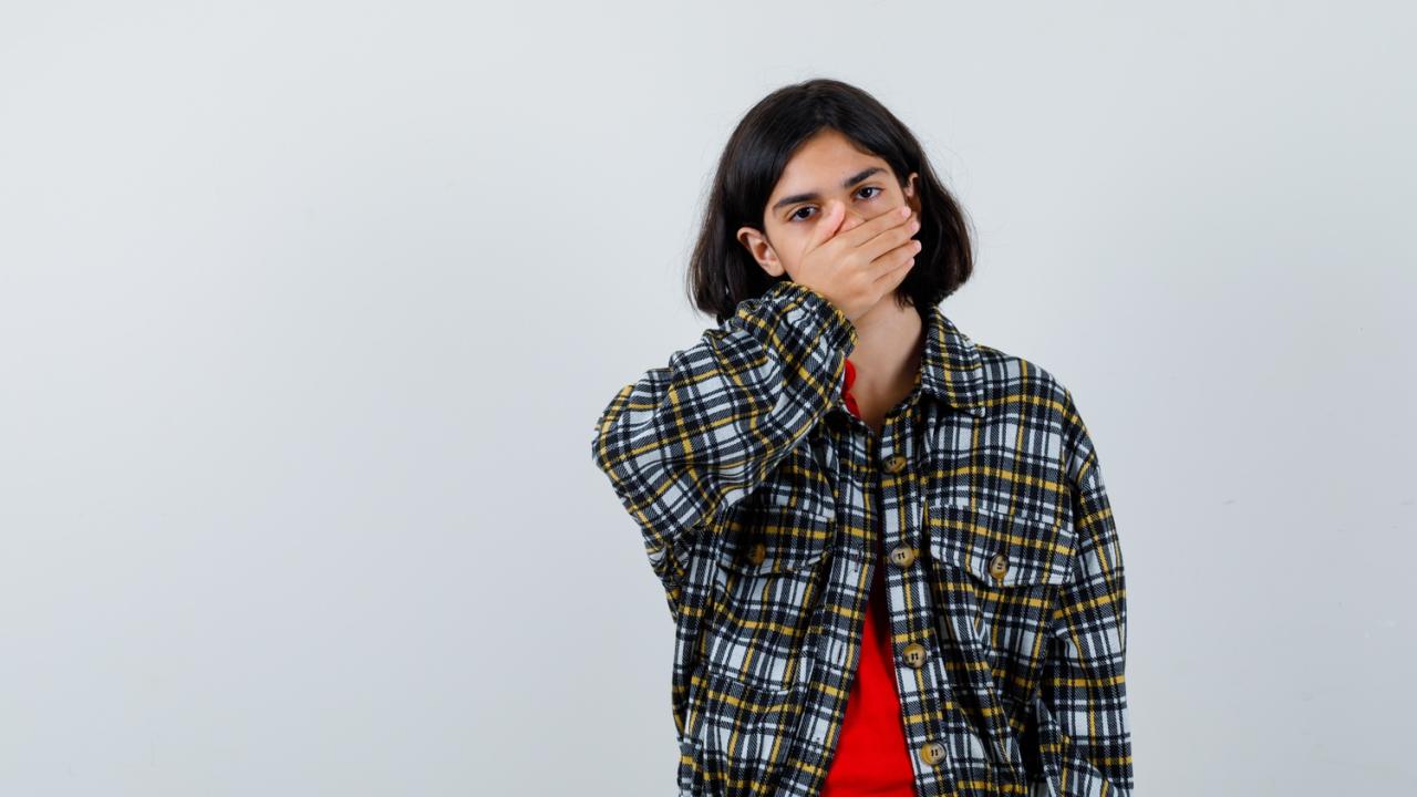 young-girl-checked-shirt-red-t-shirt-covering-mouth-with-hand-looking-surprised-front-view.jpg